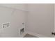 Functional laundry room with shelf and utility connections for washer and dryer at 125 Prosecco Dr, Princeton, NC 27569