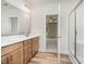 Bathroom with wood cabinets, double sinks, a large mirror, and a shower at 125 Tuskeegee Dr, Smithfield, NC 27577