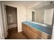 Bathroom featuring double sinks, large mirror and a view to the shower and commode at 125 Tuskeegee Dr, Smithfield, NC 27577