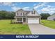 Charming two-story home featuring stone accents, a two-car garage, and a well-manicured lawn at 125 Tuskeegee Dr, Smithfield, NC 27577