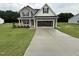 Two story home with a grey exterior, a large garage, and a well manicured front lawn at 125 Tuskeegee Dr, Smithfield, NC 27577