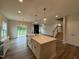 Open concept kitchen featuring white cabinets, a kitchen island, and stainless steel appliances at 125 Tuskeegee Dr, Smithfield, NC 27577