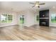 Open-concept living room featuring a modern fireplace, ceiling fan, and luxury vinyl plank flooring at 125 Tuskeegee Dr, Smithfield, NC 27577