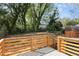 View of a well-maintained backyard with a wooden deck, grassy area, and mature trees at 13 St Augustine, Raleigh, NC 27610
