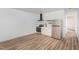 Compact kitchen featuring stainless steel appliances, white cabinets, and light wood flooring, maximizing space and functionality at 13 St Augustine, Raleigh, NC 27610