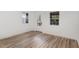 Bright living room with three windows, wood-look floors, and a door for easy access to the outside at 13 St Augustine, Raleigh, NC 27610