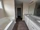 Main bathroom with double vanity, soaking tub, and separate shower showcasing modern finishes at 131 Wilderness Trl, Smithfield, NC 27577