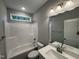 Well-lit bathroom features a tub-shower combo, white fixtures, and a large mirror at 139 Red River Dr, Selma, NC 27576