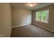 Cozy bedroom with neutral carpet, a bright window overlooking greenery, and natural light at 139 Red River Dr, Selma, NC 27576