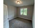 Minimalist bedroom featuring plush carpet, a bright window, and a fresh, neutral color palette at 139 Red River Dr, Selma, NC 27576