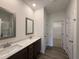 Stylish bathroom with double vanity, framed mirrors, and a separate area leading to a walk-in closet at 141 Trescott St, Smithfield, NC 27577
