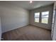 Bright bedroom with a cozy carpet, two windows offering peaceful views, and a neutral color palette at 141 Trescott St, Smithfield, NC 27577