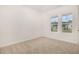 A carpeted bedroom featuring two windows at 141 Trescott St, Smithfield, NC 27577