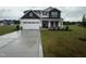 Charming two-story home featuring a pristine lawn, neutral siding, and a spacious two-car garage at 141 Trescott St, Smithfield, NC 27577