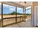 View of a screened-in back porch with wooden flooring and railing, overlooking a partially cleared lot at 143 Royal Ave, Selma, NC 27576