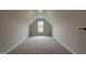 This bonus room/attic space features a large window and neutral carpeting, ready for customization at 147 Tuskeegee Dr, Smithfield, NC 27577