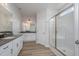 Bright bathroom with double sinks, white cabinetry, granite counters, and glass shower at 147 Tuskeegee Dr, Smithfield, NC 27577