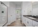 Bright bathroom featuring double sinks, white cabinets, and a glass-enclosed shower at 147 Tuskeegee Dr, Smithfield, NC 27577