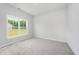 A bright bedroom featuring neutral walls, plush carpeting, and a view of the outdoors at 147 Tuskeegee Dr, Smithfield, NC 27577