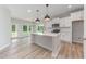 Bright, modern kitchen features white cabinets, an island with pendant lighting, and stainless steel appliances at 147 Tuskeegee Dr, Smithfield, NC 27577