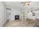 Bright living room with a fireplace, ceiling fan, and an open kitchen concept at 147 Tuskeegee Dr, Smithfield, NC 27577