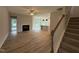 Open-concept living room with hardwood floors, a fireplace, and stairs to upper level at 147 Tuskeegee Dr, Smithfield, NC 27577