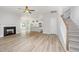 Open-concept living room with a fireplace, staircase, and a view of the modern kitchen at 147 Tuskeegee Dr, Smithfield, NC 27577