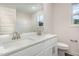 Bright bathroom featuring double sinks, white cabinets, and a large mirror at 15 Lupin Dr, Smithfield, NC 27577