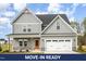 Beautiful two-story home featuring gray siding, a stone-accented foundation, and an attached two-car garage at 15 Lupin Dr, Smithfield, NC 27577