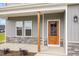Inviting entryway with a wooden front door, stone accents, and gray siding for a modern, stylish appeal at 15 Lupin Dr, Smithfield, NC 27577