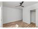 Neutral bedroom featuring wood-look floors, ceiling fan, closet with sliding doors, and clean lines at 15 St Augustine, Raleigh, NC 27610