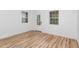Bright, empty room with beautiful wood-look floors, white walls, and two windows providing lots of natural light at 15 St Augustine, Raleigh, NC 27610