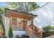 Exterior shot of a home with wooden porch and stylish railings, leading to a glass-paneled front door at 15 St Augustine, Raleigh, NC 27610
