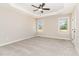 Bright bedroom with tray ceilings, carpeted floor, ceiling fan, and natural light at 163 Royal Ave, Selma, NC 27576