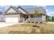 Beautiful new home with attached garage, covered porch, manicured lawn, and young shade tree at 163 Royal Ave, Selma, NC 27576