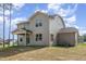 Two-story home with neutral siding, showcasing back porch and well-lit windows under a partly cloudy sky at 18 Bonnybrook Ct, Selma, NC 27576