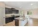 Well-lit kitchen featuring an island with granite countertops, dark cabinets, and stainless steel appliances at 18 Bonnybrook Ct, Selma, NC 27576