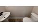 Small powder room with a pedestal sink and a toilet in a neutral color palette at 18 Bonnybrook Ct, Selma, NC 27576