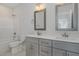 This bathroom features tile floor, gray cabinets with double sinks, gray framed mirrors and a tub and shower combination at 18 S Rowsham Pl, Smithfield, NC 27577