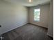 This bedroom features neutral walls, carpet flooring, and a window providing natural light at 18 W Emily Gardens Dr, Selma, NC 27576