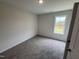 A clean bedroom with neutral walls, plush carpeting, and a window providing natural light at 18 W Emily Gardens Dr, Selma, NC 27576