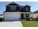 Charming two-story home featuring a two-car garage, blue siding, and a well-manicured lawn at 18 W Emily Gardens Dr, Selma, NC 27576