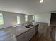 The kitchen island offers space for dining and food prep with views of the staircase and multiple windows at 18 W Emily Gardens Dr, Selma, NC 27576