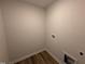 A cozy laundry room featuring wood floors and convenient hookups, making laundry chores a breeze at 18 W Emily Gardens Dr, Selma, NC 27576