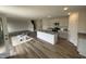 Spacious living area with hardwood floors adjoining kitchen with island and granite countertops at 18 W Emily Gardens Dr, Selma, NC 27576