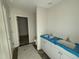 Bathroom featuring double vanities, white cabinets, vinyl floors, and access to closet at 18 W Emily Gardens Dr, Selma, NC 27577