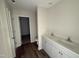 Bathroom with double sinks, modern white cabinets, and vinyl floors at 18 W Emily Gardens Dr, Selma, NC 27576