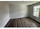 Bright bedroom featuring dark wood-look floors, white walls, and a large window at 18 W Emily Gardens Dr, Selma, NC 27576