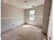 A bedroom under construction with gray walls, white trim, and a window at 18 W Emily Gardens Dr, Selma, NC 27577