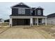 New two-story home featuring dark siding, a two-car garage, and stone accents at 18 W Emily Gardens Dr, Selma, NC 27577